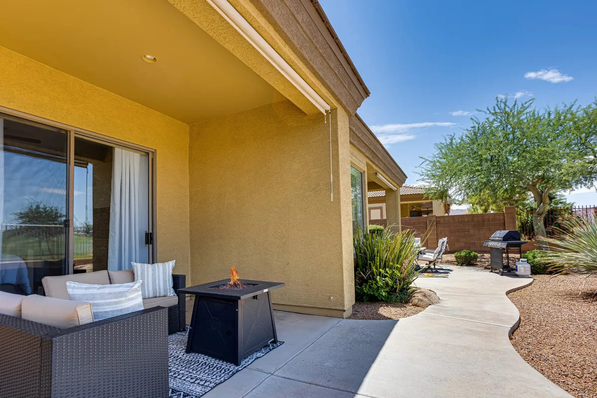 Showcasing a beautifully landscaped pathway leading to an outdoor seating area, complete with a fire pit and grill, this scene encourages community interaction and relaxation under the open sky. The fire pit area is a focal point for evening gatherings.